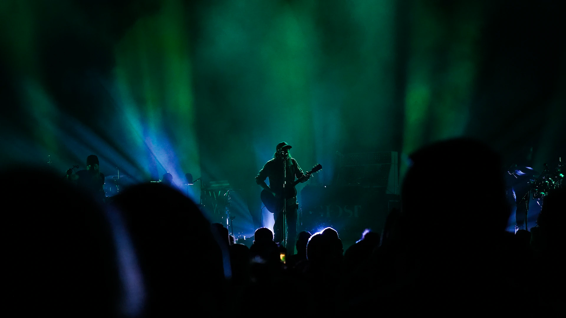 man in black shirt playing guitar on stage