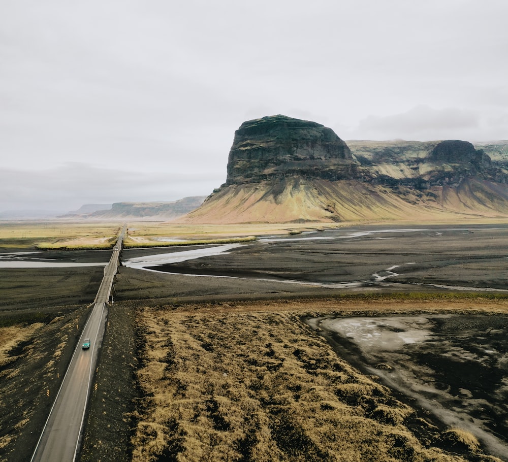 gray asphalt road in the middle of brown field