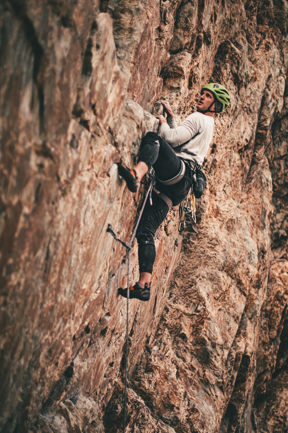 man in black jacket climbing on brown rock mountain during daytime