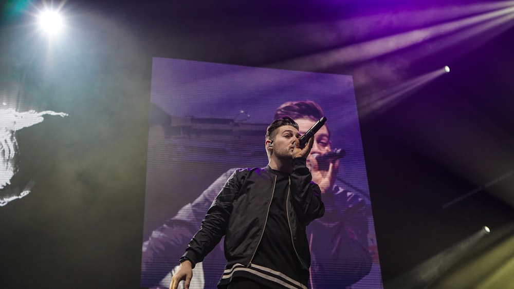 man in black jacket holding microphone