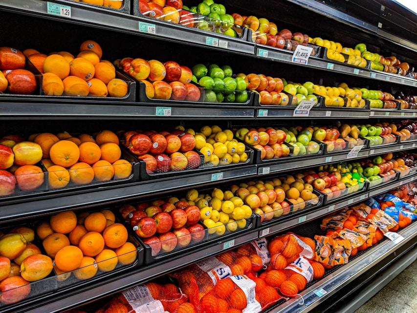 Einkaufswagen in einem Supermarktgang zwischen gefüllten Regalen
