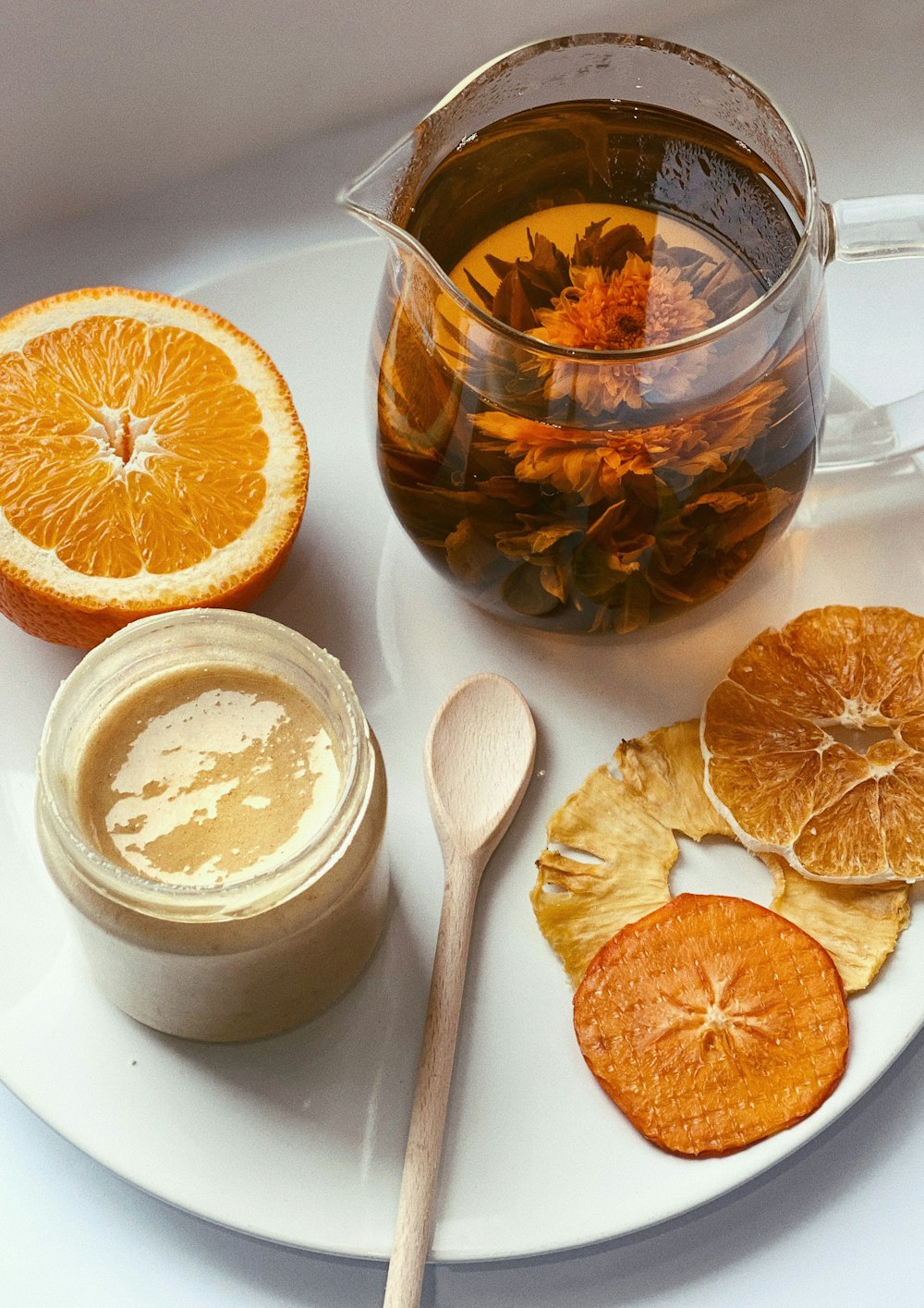 sliced orange fruit on white ceramic bowl beside clear glass jar with white liquid