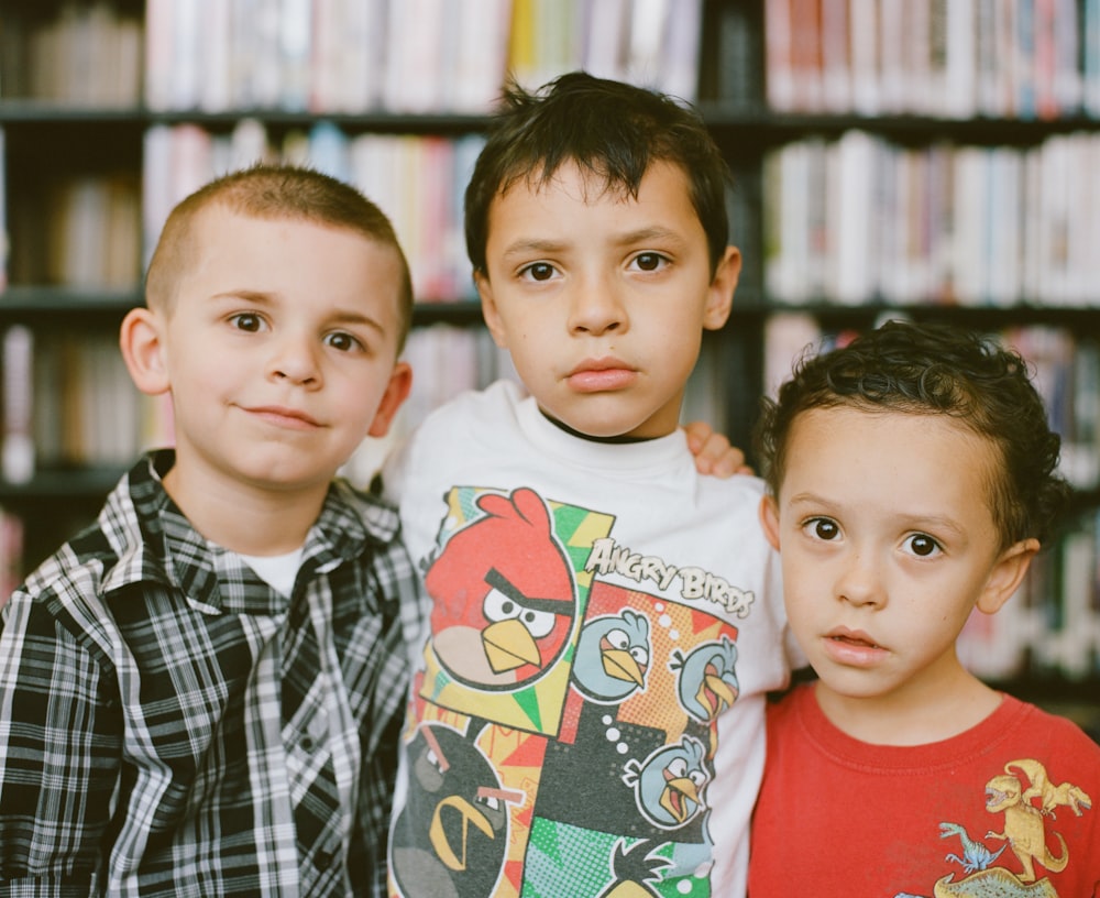 boy in red crew neck shirt beside boy in white and black checkered button up shirt