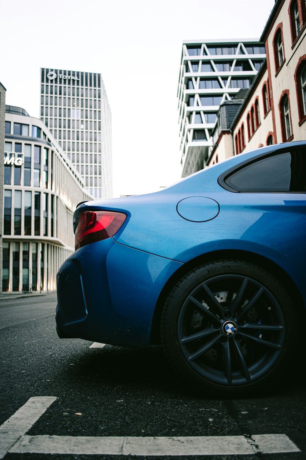 blue car parked near white building during daytime