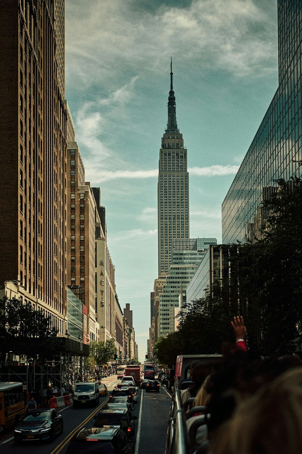 cars on road in between high rise buildings during daytime