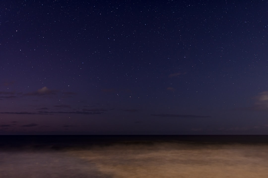 body of water under blue sky during night time