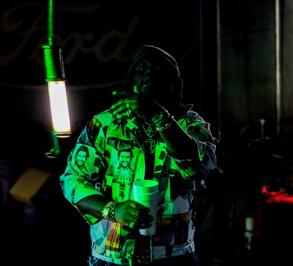 Hombre en chaqueta verde y negra sosteniendo micrófono