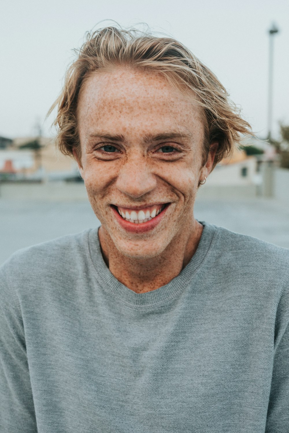 homem na camisa cinza do pescoço da tripulação sorrindo