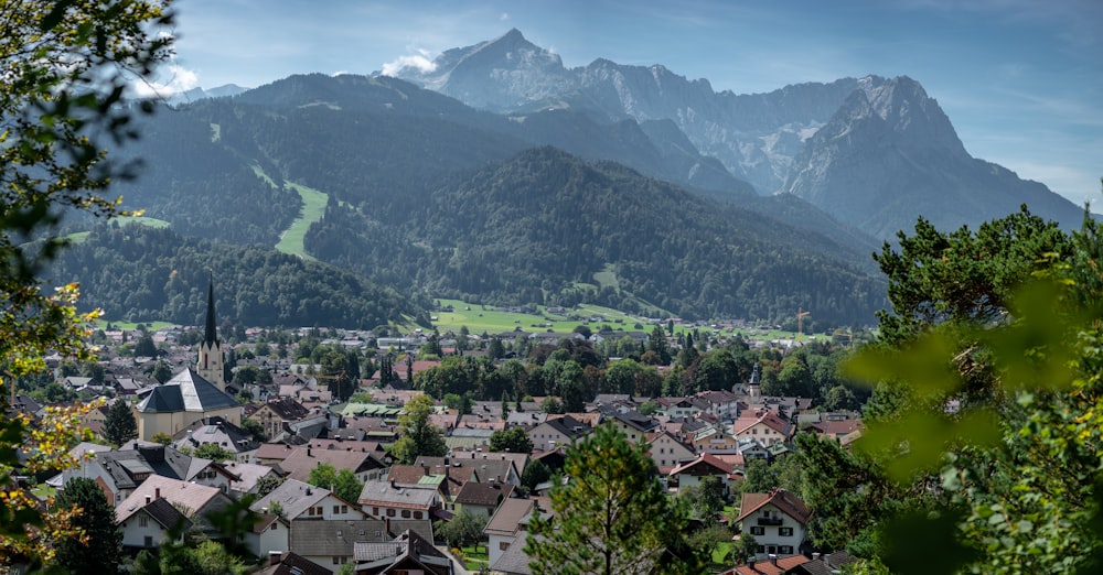 aerial view of city near green mountains during daytime