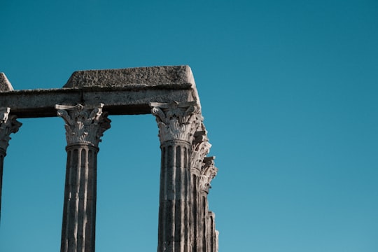 gray concrete pillar under blue sky during daytime in Roman Temple of Évora Portugal