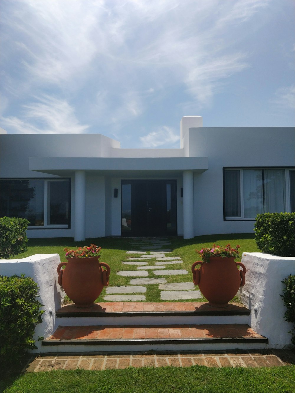 white concrete house under white clouds during daytime