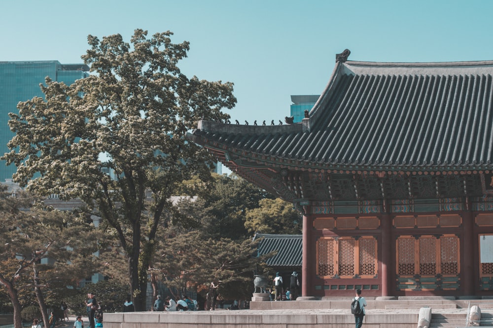 people walking on street near red and brown temple during daytime