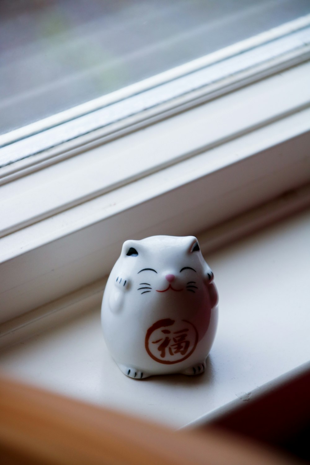 white and red ceramic cat figurine