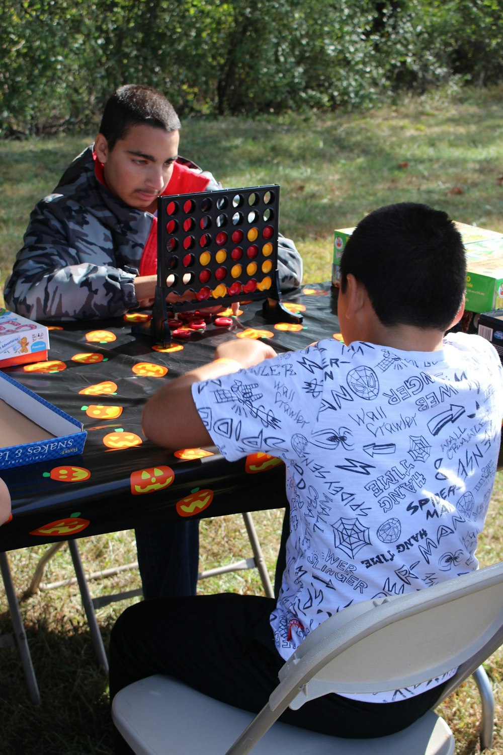 boy in red and black hoodie playing chess