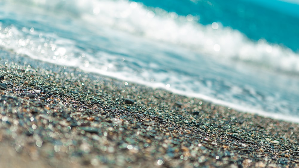 water waves on brown sand during daytime