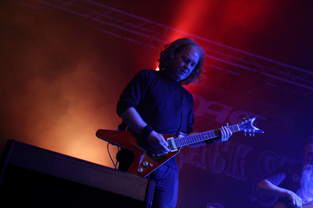 man in black long sleeve shirt playing electric guitar