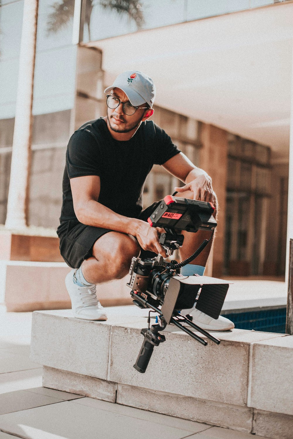 man in black crew neck t-shirt and gray denim jeans sitting on gray concrete bench