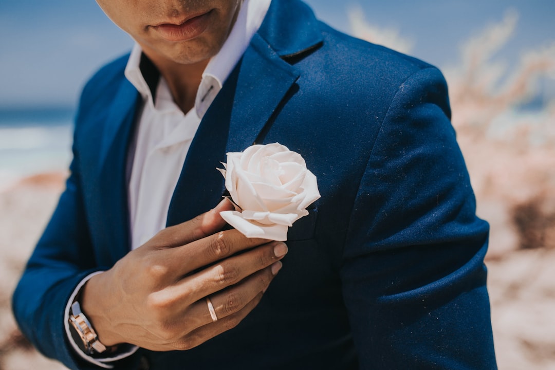 man in blue blazer holding white paper