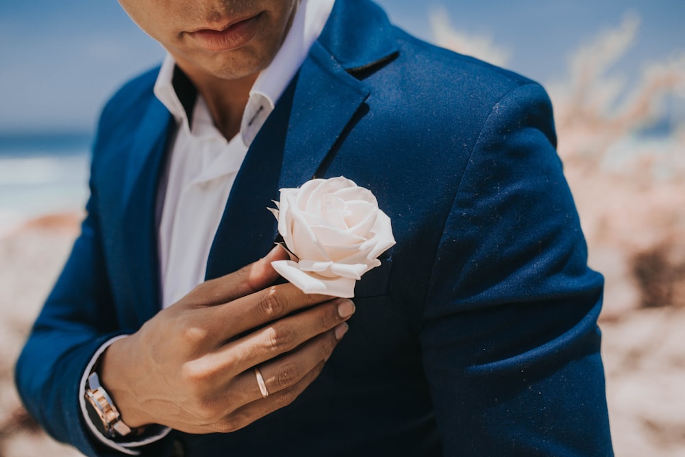 uomo in blazer blu che tiene la carta bianca