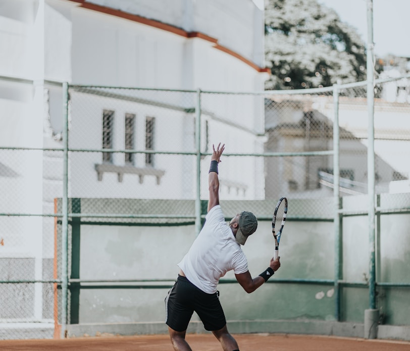 man in white t-shirt playing basketball during daytime