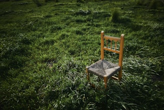 A beautifully crafted rattan chair placed in a serene outdoor setting.