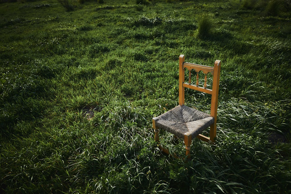 brown wooden chair on green grass field during daytime