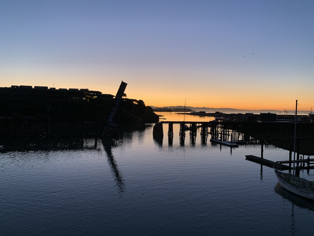 silhouette of boat on water during sunset