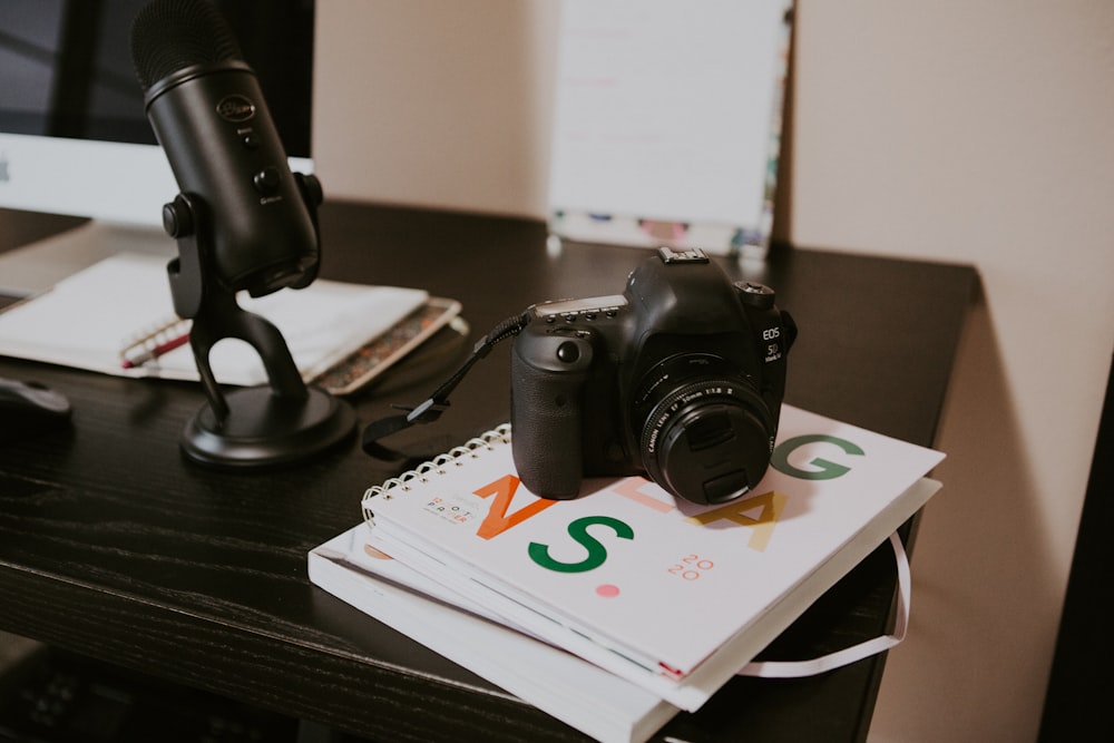 black canon dslr camera on brown wooden table