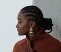 woman in brown coat wearing gold earrings