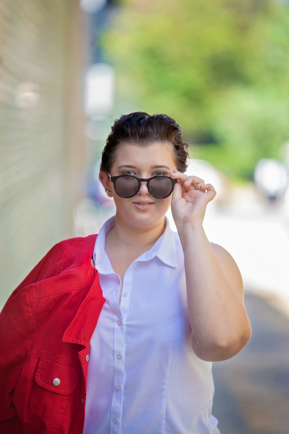 Mujer con chaleco rojo abotonado con gafas de montura negra