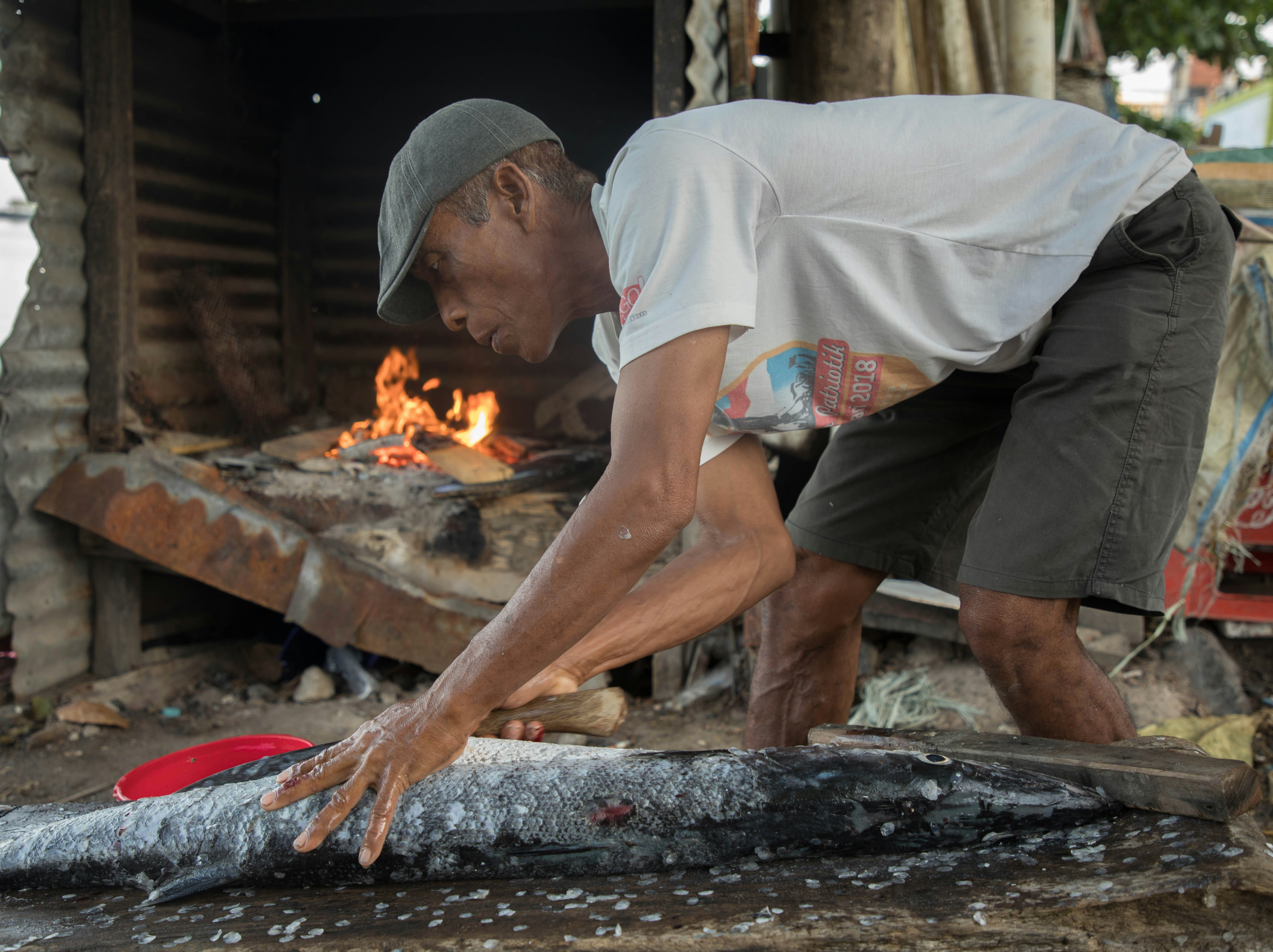 man in white shirt and gray shorts holding white plastic bag