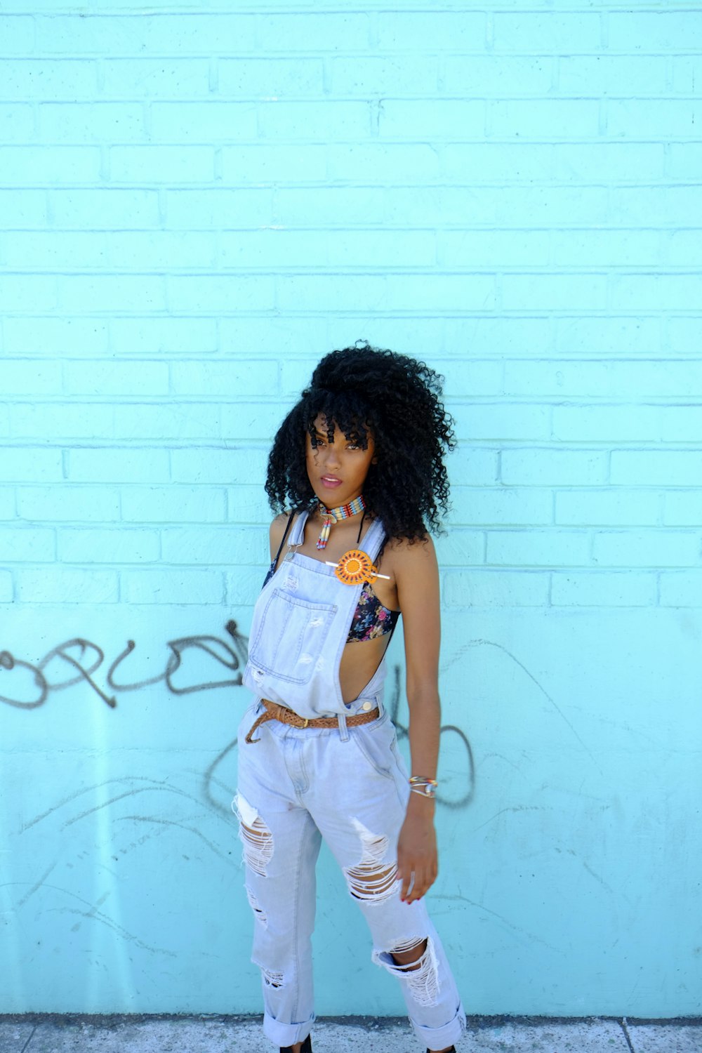 woman in white and red tank top and white shorts standing beside wall