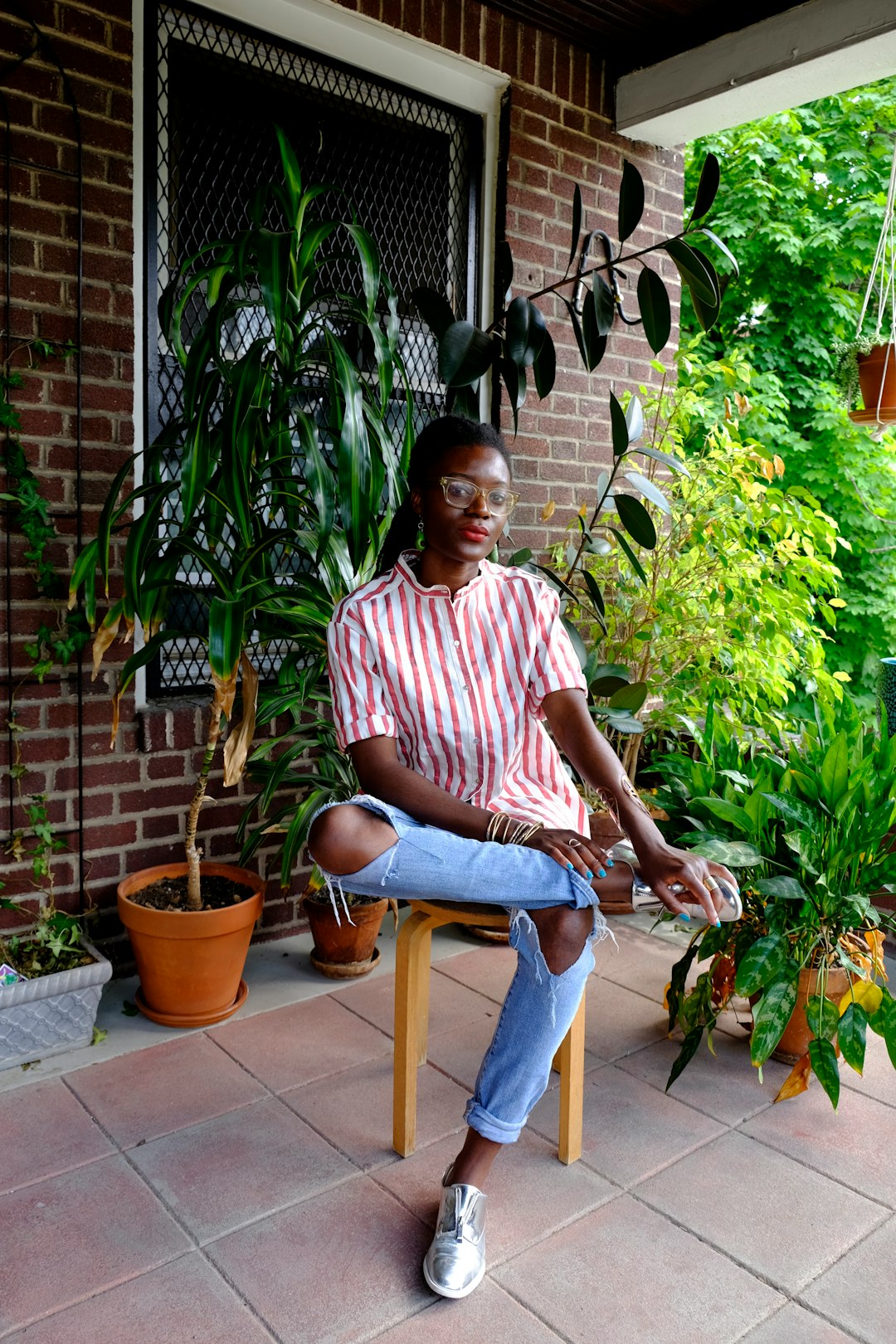 man in red and white stripe polo shirt sitting on brown wooden chair