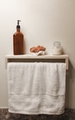 A serene bathroom shelf styled with light18 products and royal blue towels.