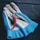 A pair of blue and white work gloves lies on a dark wooden surface with a single red chili pepper resting on top.