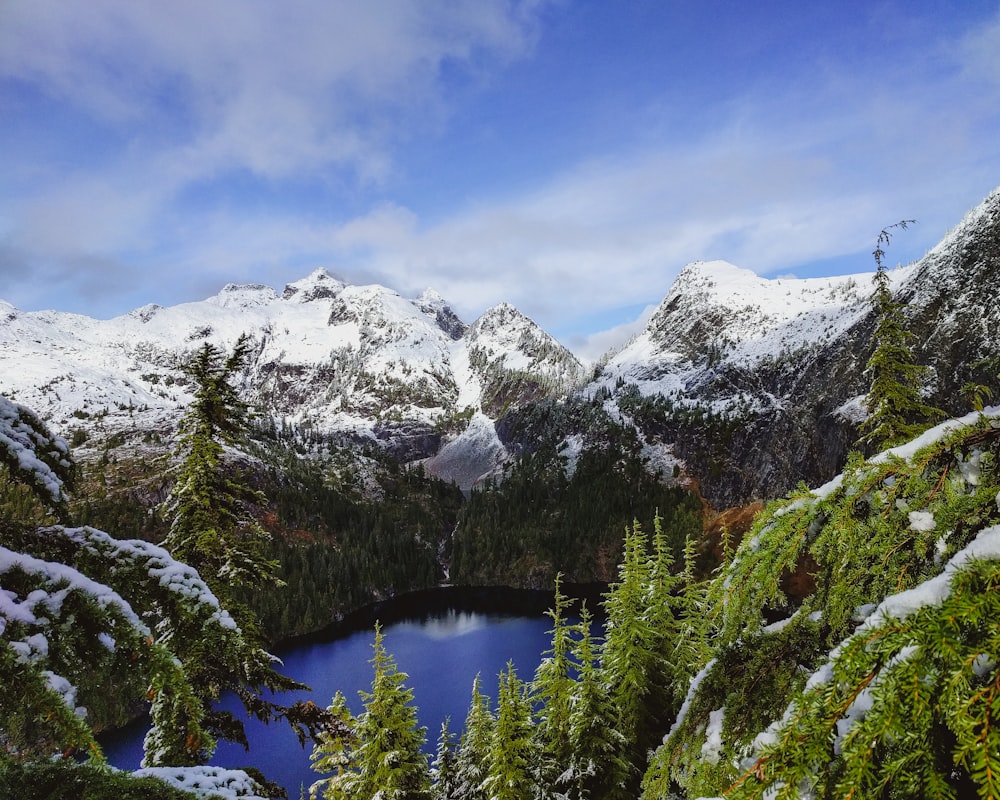 a view of a lake surrounded by snow covered mountains