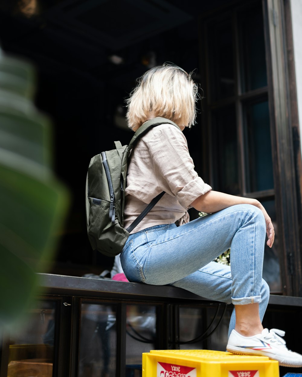 Donna in jeans blu denim seduta su panca di legno marrone