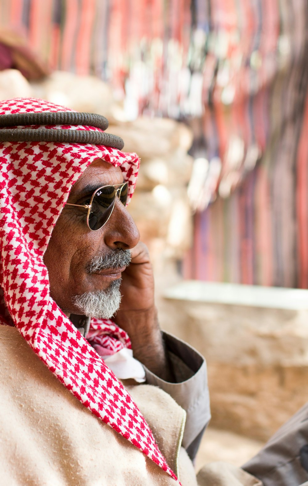 man in red and white scarf wearing gold framed aviator sunglasses