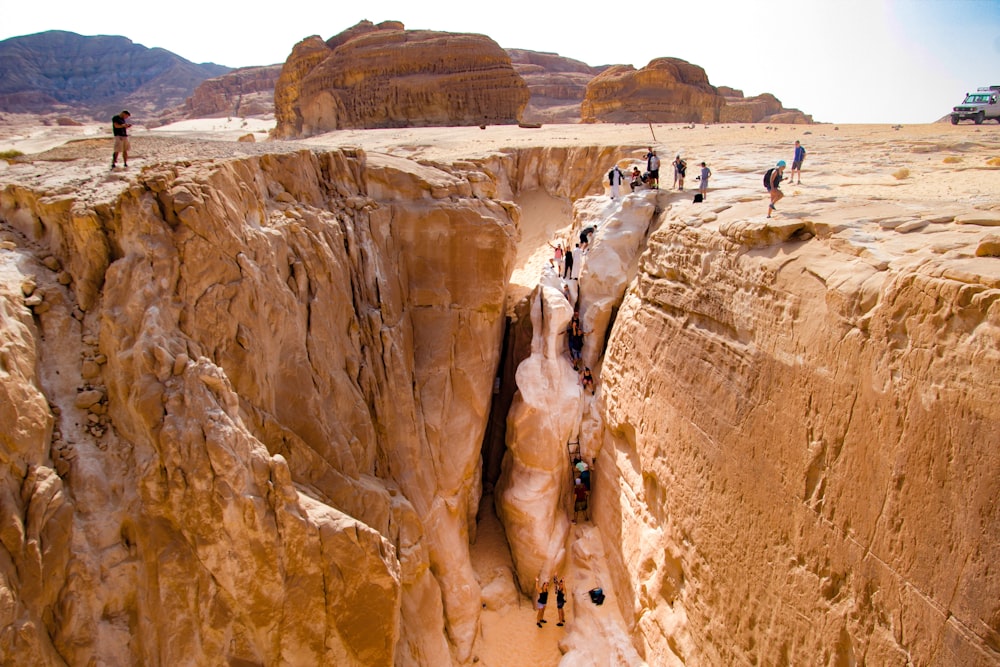 people walking on brown rock formation during daytime