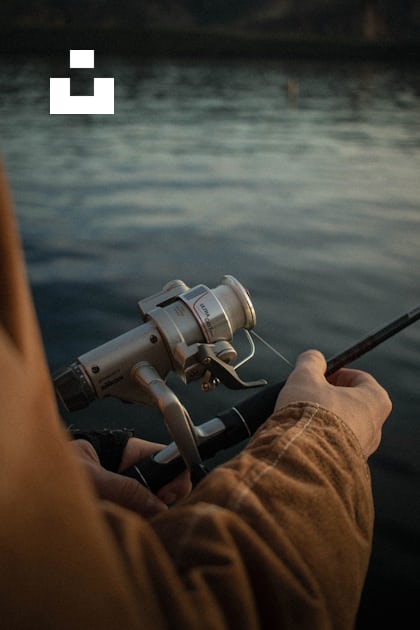 Person in brown pants and black and gray fishing rod photo – Free