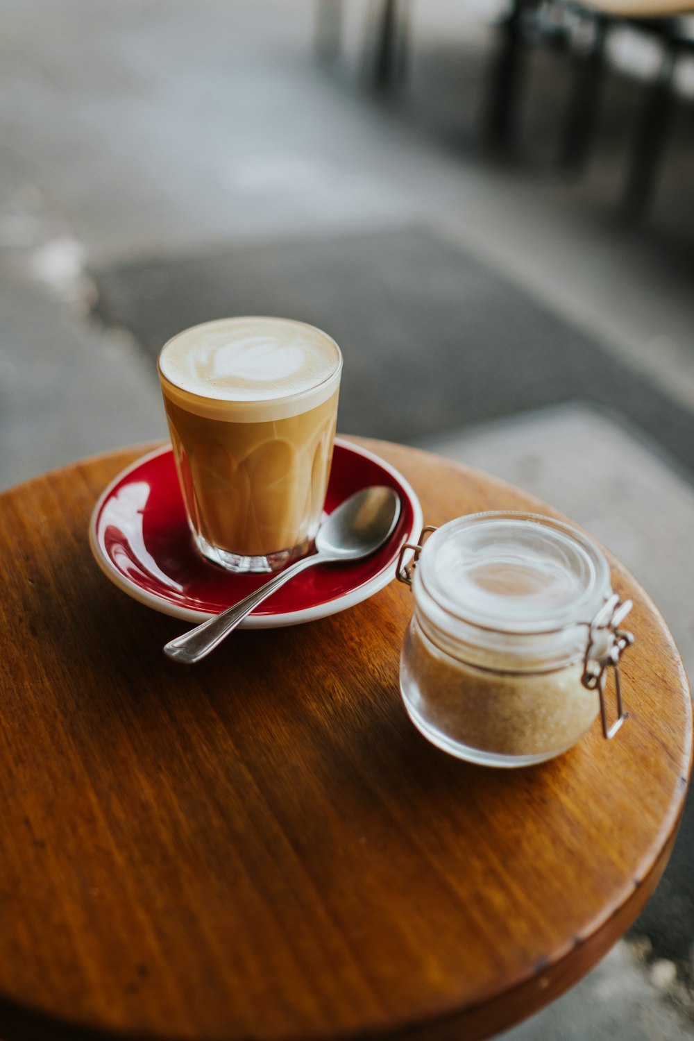 clear glass mug with brown liquid on brown wooden table