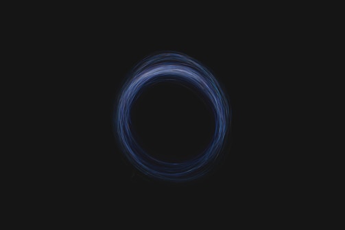 A circular pattern, resembling a vortex or swirling effect, is depicted against a dark background. The circle is composed of thin, semi-transparent lines with varying shades of blue.