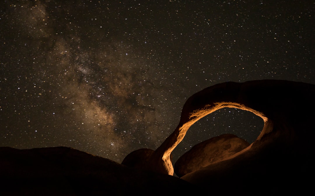 brown rock formation under starry night