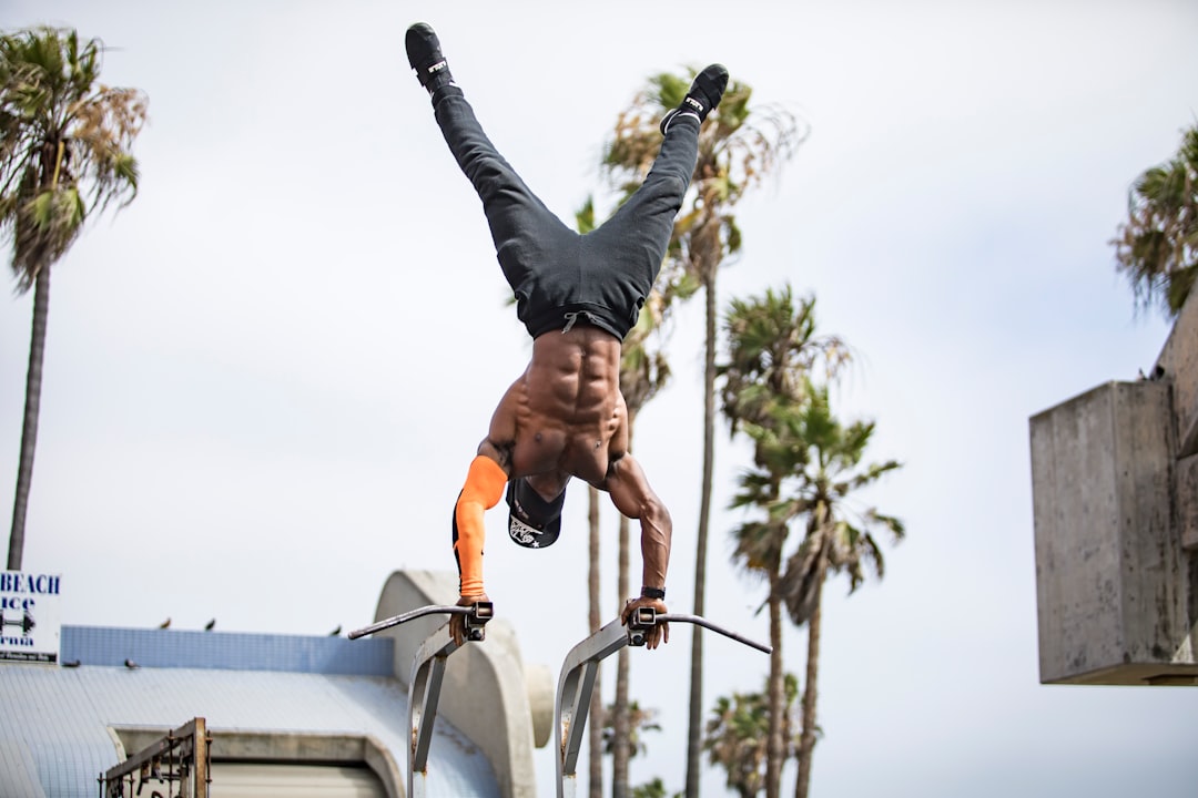 man in black pants and black shoes doing yoga during daytime