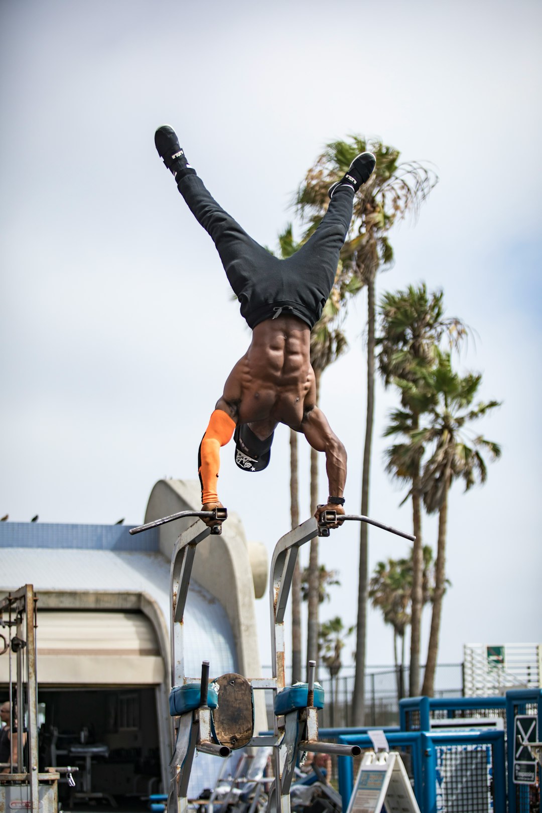 man in black tank top and black pants doing yoga during daytime