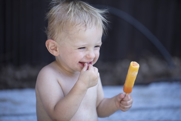 A joyful child enjoying a sweet icy smile dessert at a family gathering.