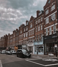 cars parked in front of brown concrete building during daytime