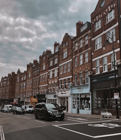 cars parked in front of brown concrete building during daytime