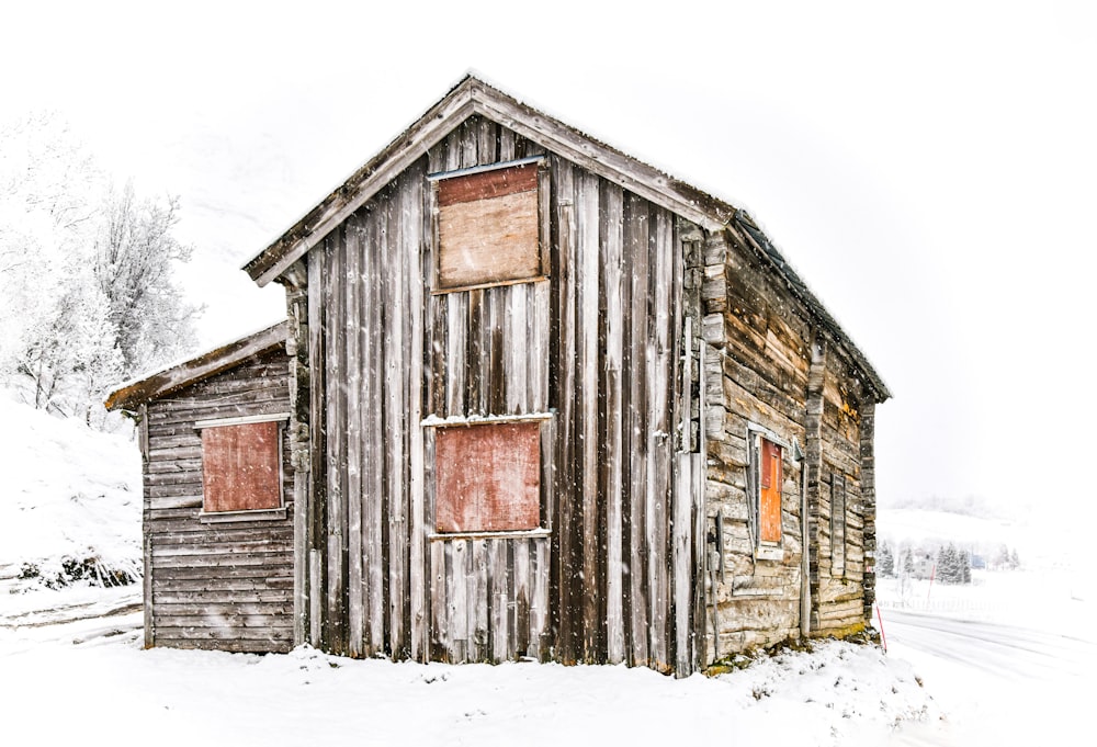 brown wooden house on snow covered ground