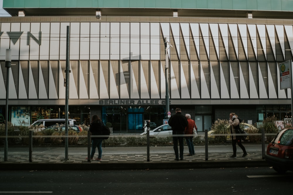 people walking on sidewalk near building during daytime